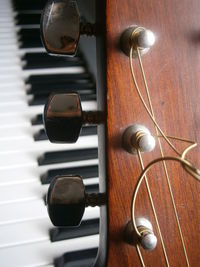 Close-up of guitar against piano