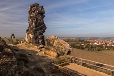 Rock formations in city against sky