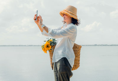 Portrait beautiful  woman in casual wearing straw hat. cheerful girl taking selfie during vacation.