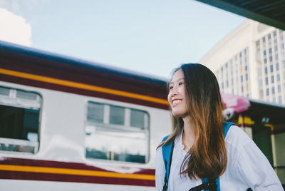 Portrait of smiling woman standing by train