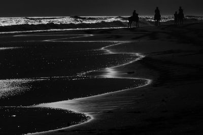 Silhouette man on beach against sky during winter