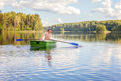 Man swimming in lake against sky