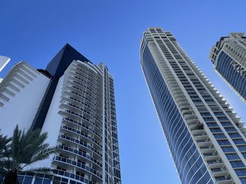 Low angle view of skyscrapers against clear blue sky