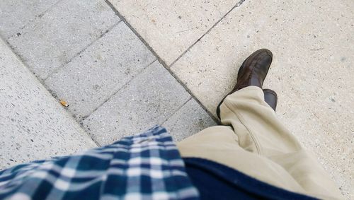 Low section of man standing on footpath