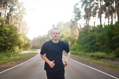 Portrait of young man standing on road