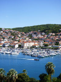 Townscape by sea against clear blue sky