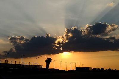 Silhouette city against sky during sunset