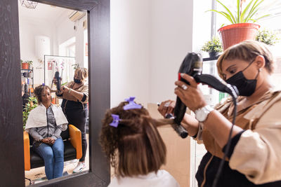 Hairdresser styling customers hair at salon