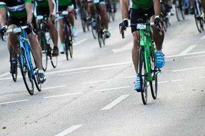 Low section of athletes cycling on road during race
