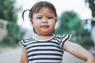 Portrait of baby girl standing on footpath