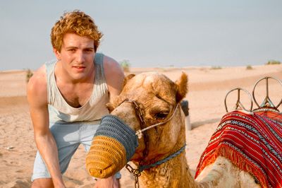 Portrait of young man in desert  with camel