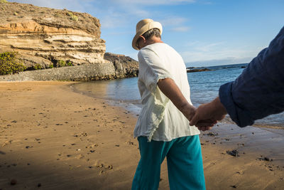 Couple with holding hands walking at beach