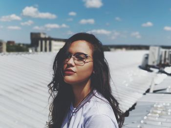 Portrait of young woman against sky