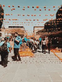 People walking in city against sky