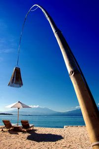 Pendant light hanging with bamboo over deck chairs at beach