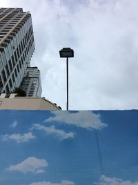 Low angle view of modern building against cloudy sky