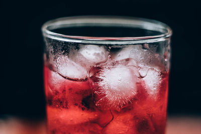 Close-up of red wine glass against black background