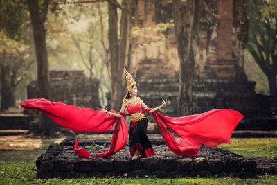 Woman in traditional clothing standing outdoors 