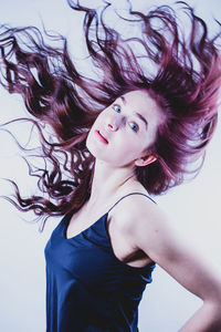 Portrait of beautiful young woman against white background