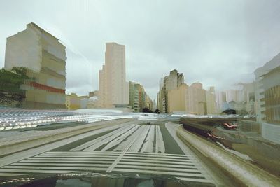 Cars on road in city against sky