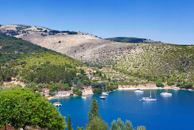 Scenic view of sea and mountains against blue sky