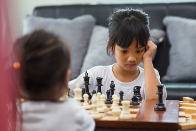 Full length of boys playing on chess board