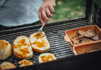 Person preparing food on barbecue grill