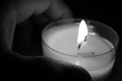 Close-up of hand holding candle