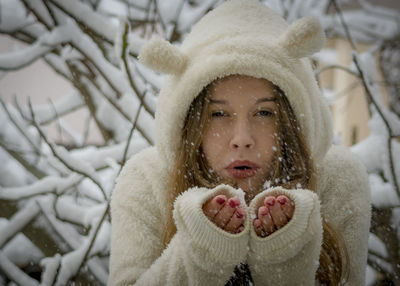 Close-up of girl blowing snow