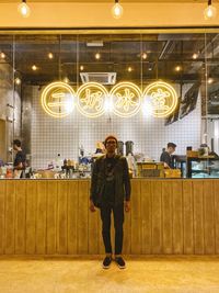 Full length portrait of a young woman standing on table