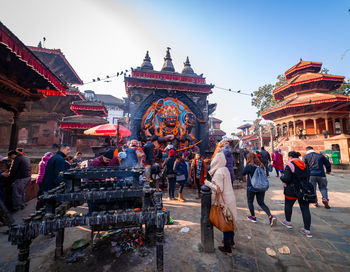 Group of people outside temple against buildings