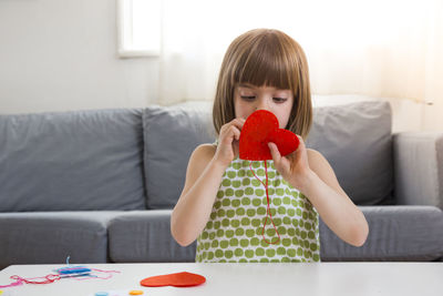 Portrait of embroidering little girl at home