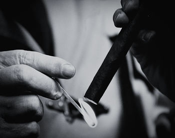 Cropped image of man holding cigarette