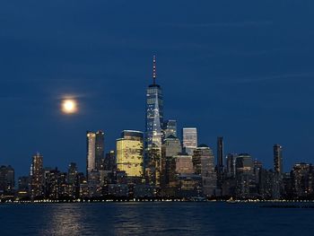 Illuminated buildings in city at waterfront