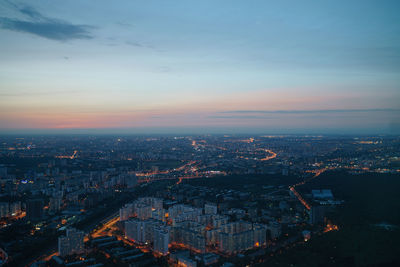 Aerial view illuminated city against sky at sunset