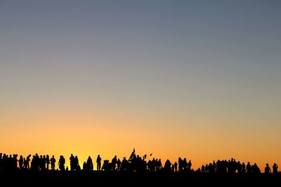 Silhouette people against clear sky during sunset