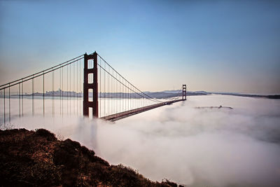 View of suspension golden gate bridge against cloudy sky