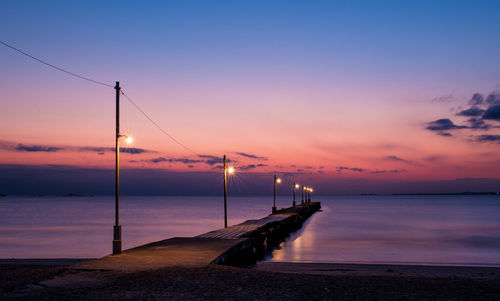 Scenic view of jetty over river at dusk