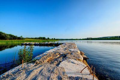 Scenic view of lake against clear blue sky