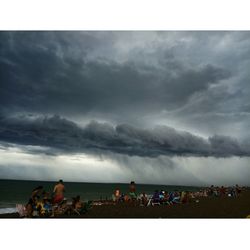 People at beach against sky