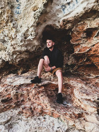 Young men sitting on rock