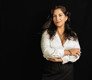 Business latin woman in white shirt and black background person