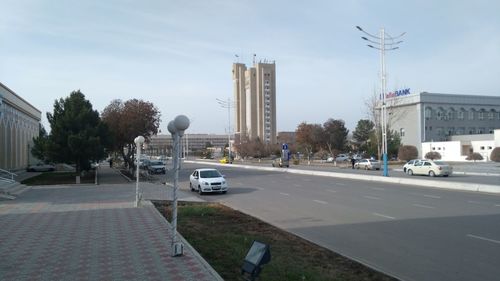 Cars on street in city against sky