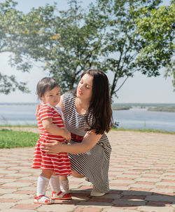 Girl with mother and daughter against trees