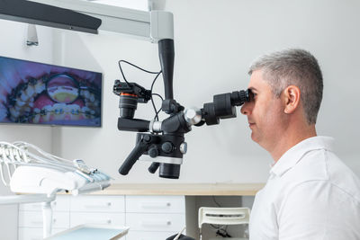 Side view of man photographing with camera