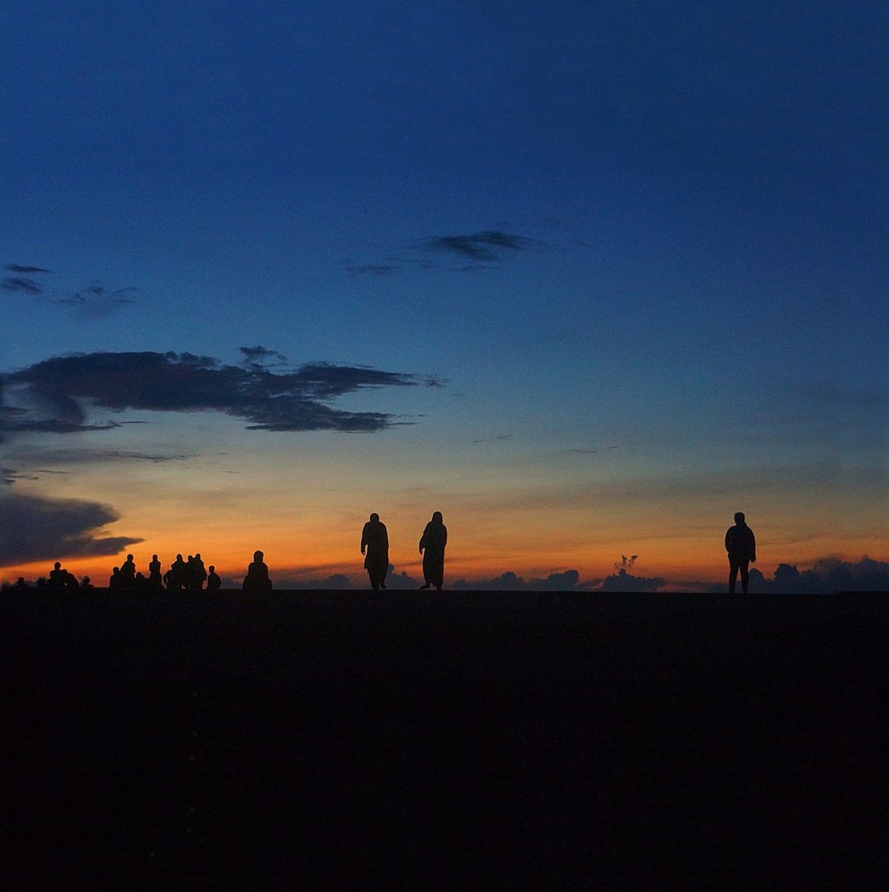 silhouette, sunset, men, lifestyles, leisure activity, togetherness, tranquility, standing, copy space, tranquil scene, orange color, full length, beauty in nature, sky, scenics, blue, dusk, nature