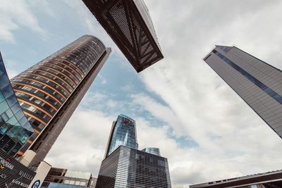 Low angle view of modern building against cloudy sky