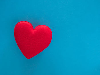 Close-up of red heart shape against blue background