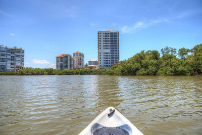 Scenic view of river by city against sky