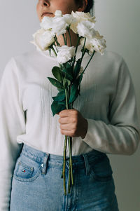 Midsection of person holding rose bouquet